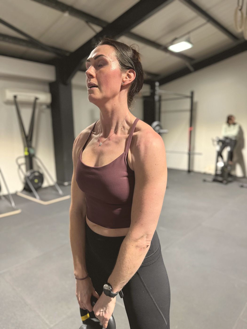A member focused mid-set, holding a kettlebell